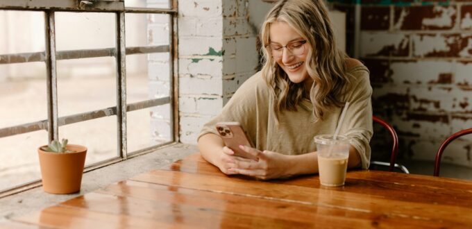 Woman laughing at her phone while texting, surrounded by the new dating slang taking over 2026