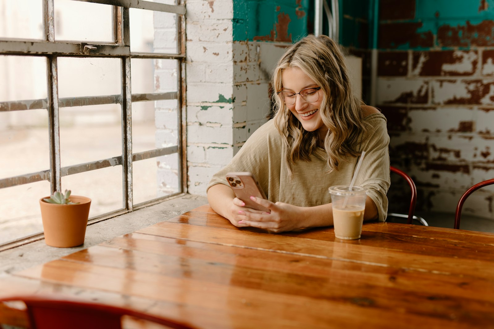 Woman laughing at her phone while texting, surrounded by the new dating slang taking over 2026