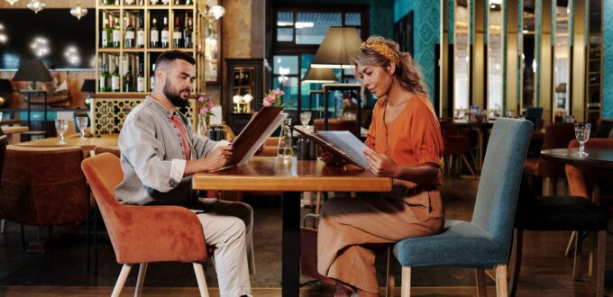 Couple reviewing the menu together at a stylish restaurant on a date