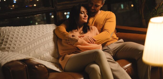 Couple embracing warmly on a couch, illustrating the trust and intimacy at the center of fetish psychology