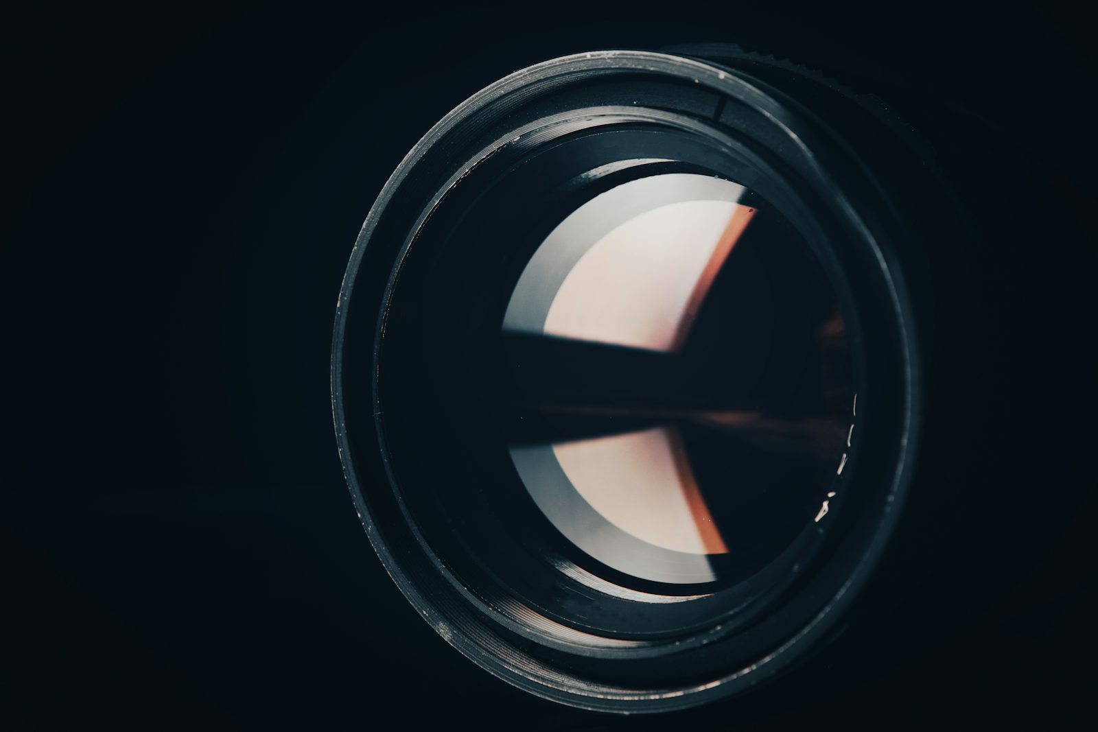 Close-up of a security camera lens in the dark, representing surveillance footage from real honeypot robbery cases