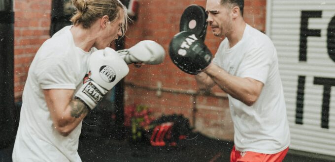 Two men sparring inside a boxing gym, training before dating and building confidence