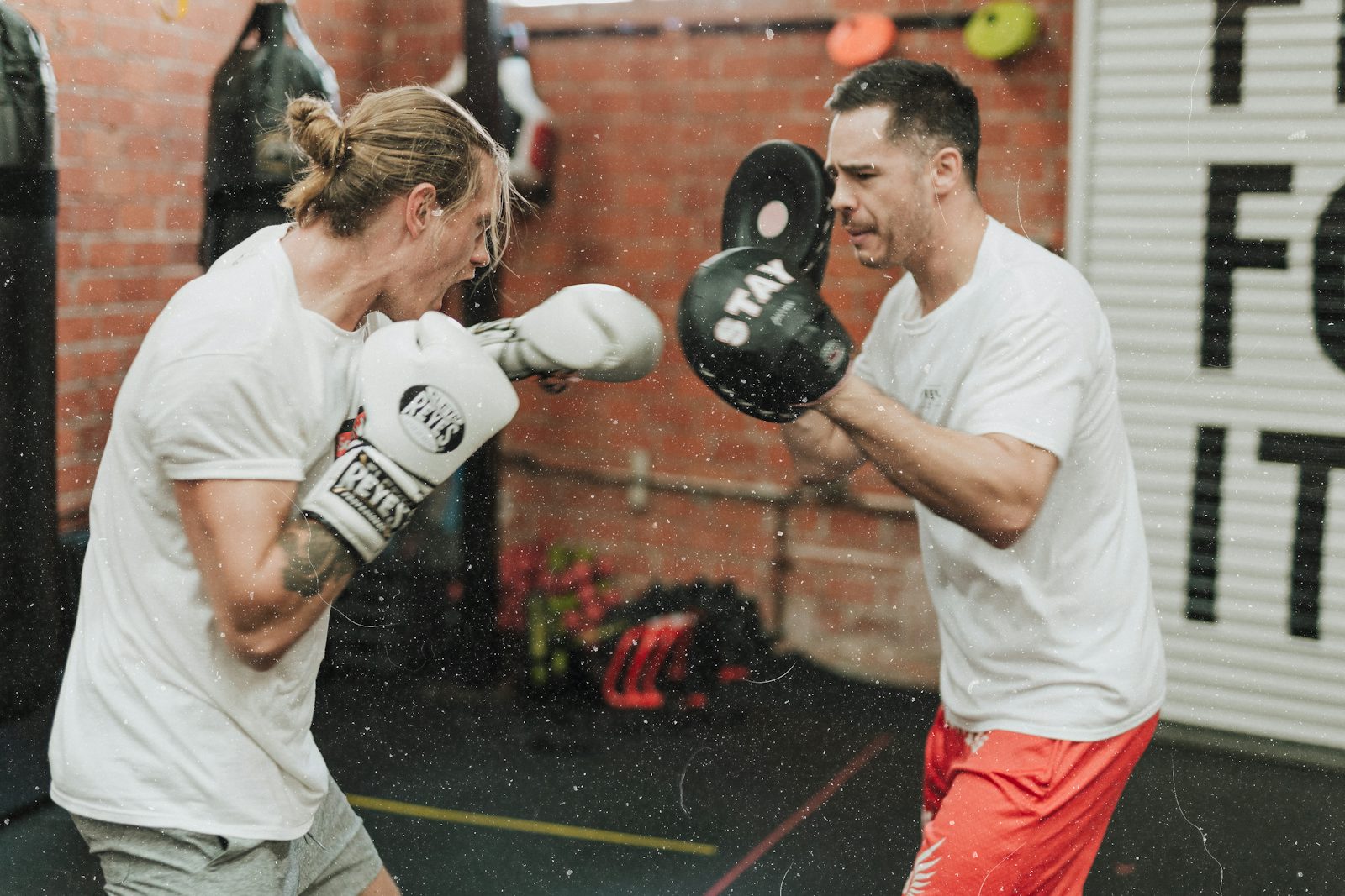 Two men sparring inside a boxing gym, training before dating and building confidence