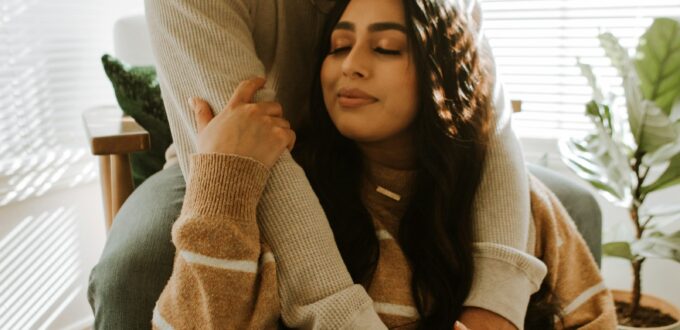 Smiling couple sitting together at home, warm modern portrait