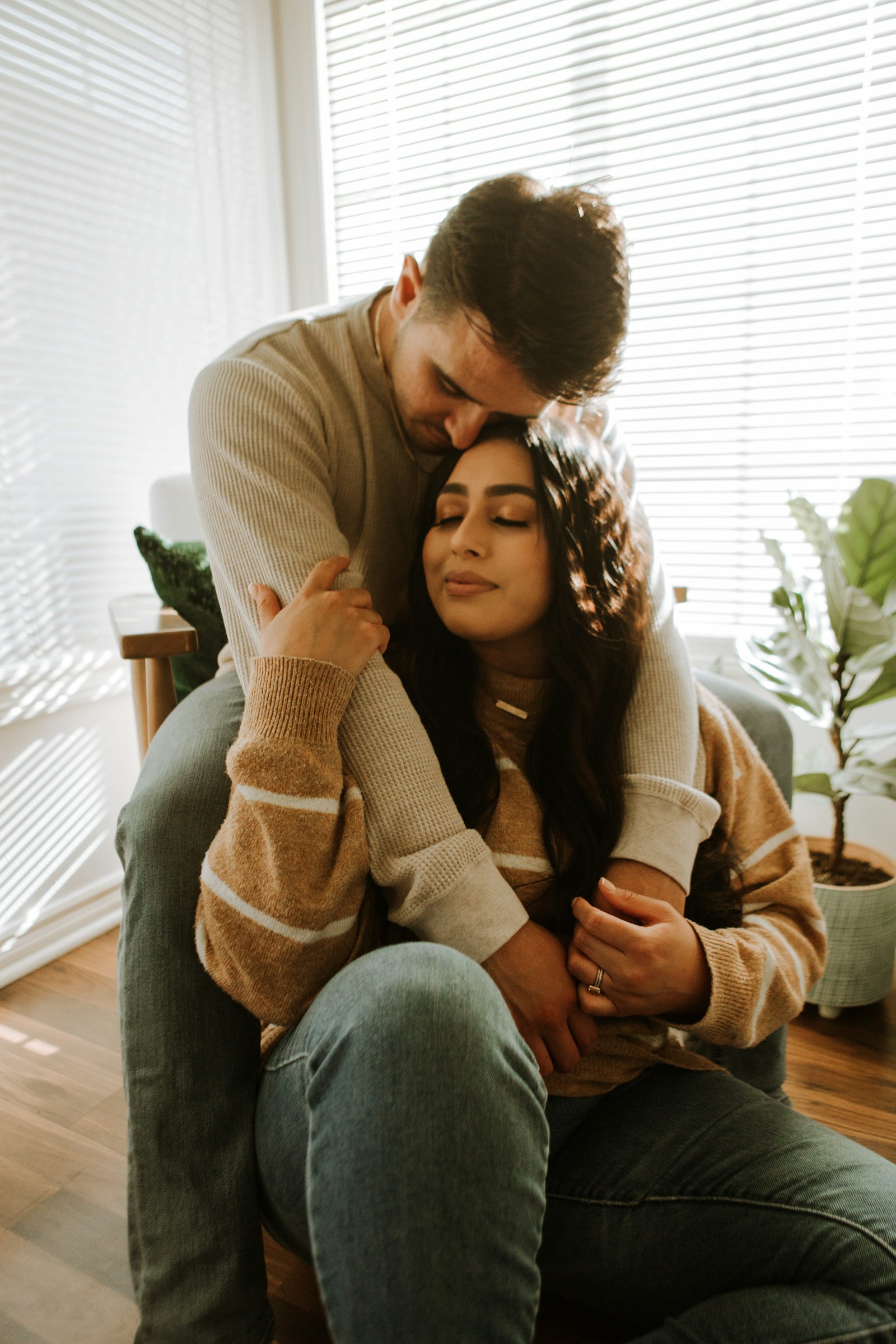 Smiling couple sitting together at home, warm modern portrait
