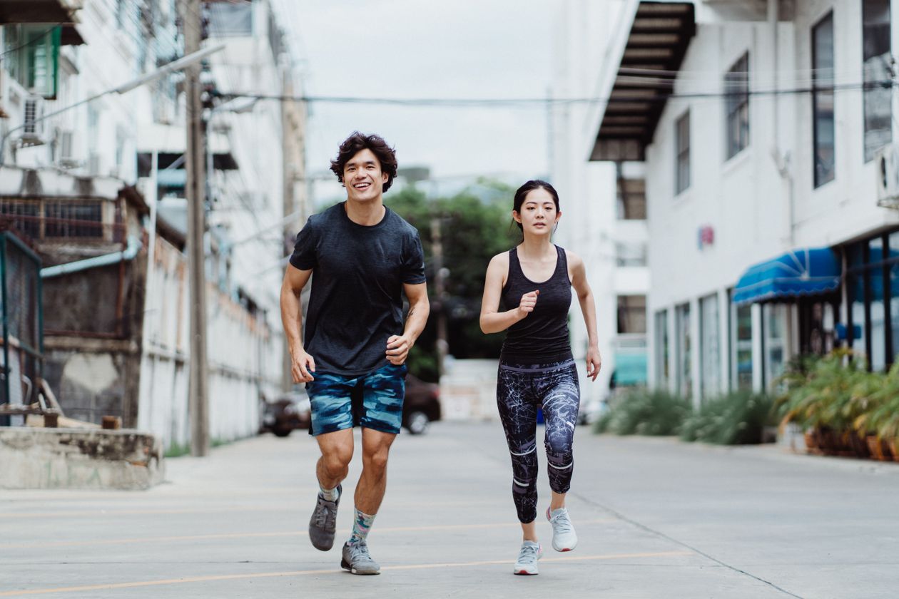Couple jogging outdoors together to stay active while dating
