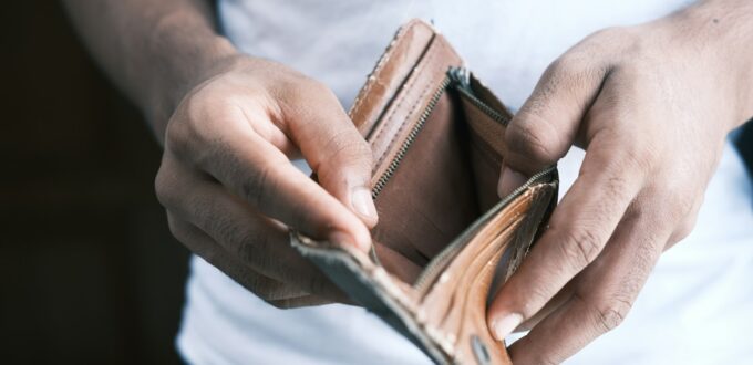 Man looking into an empty wallet, a consequence of simping in online dating