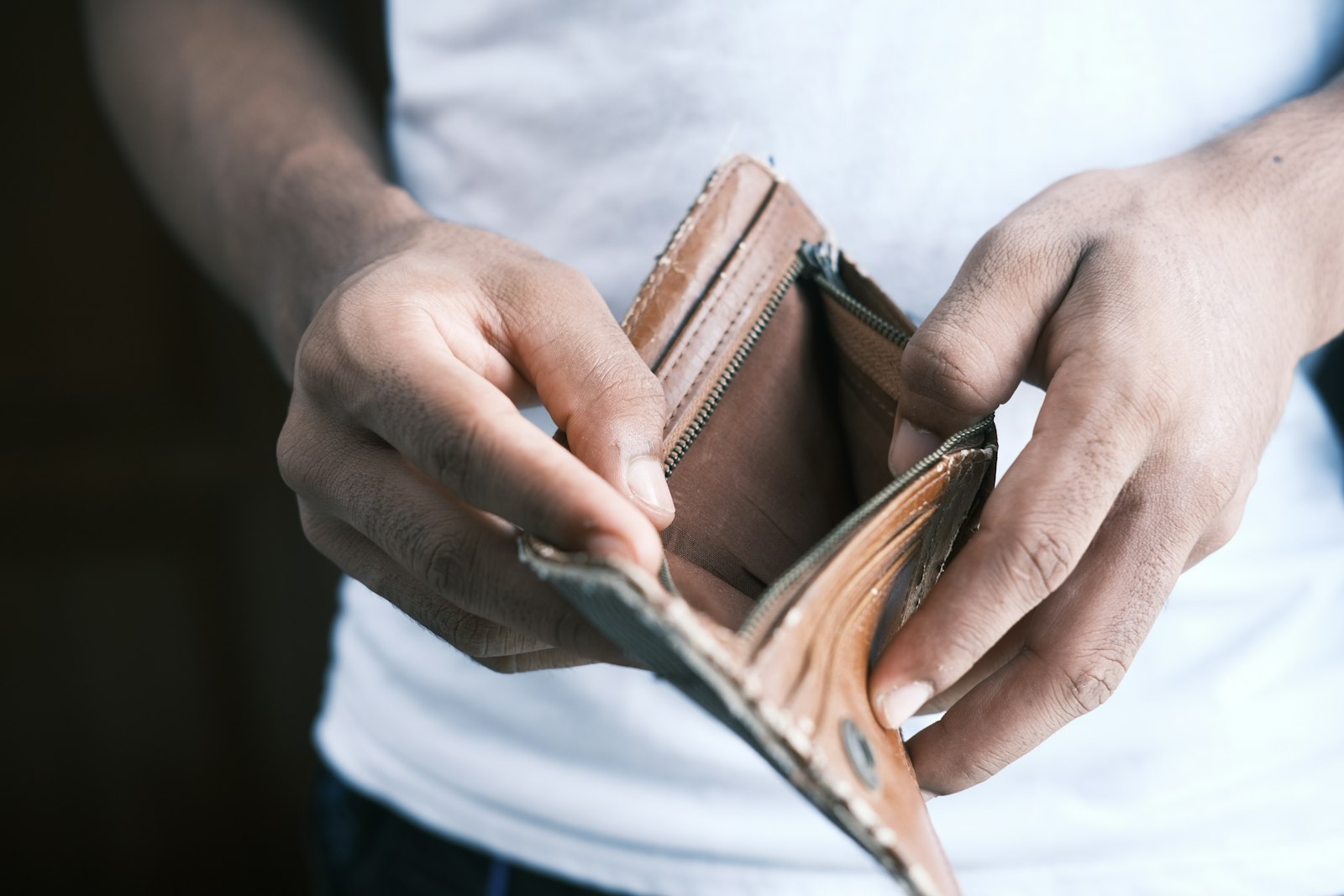 Man looking into an empty wallet, a consequence of simping in online dating