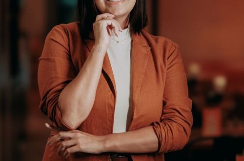Confident woman smiling in a cozy café, enjoying her own company