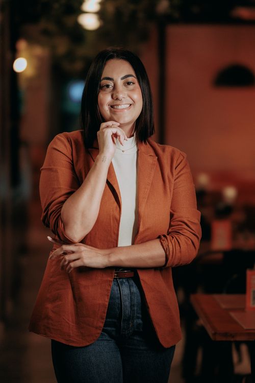 Confident woman smiling in a cozy café, enjoying her own company