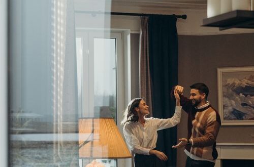 Happy couple dancing together in a cozy, candlelit living room