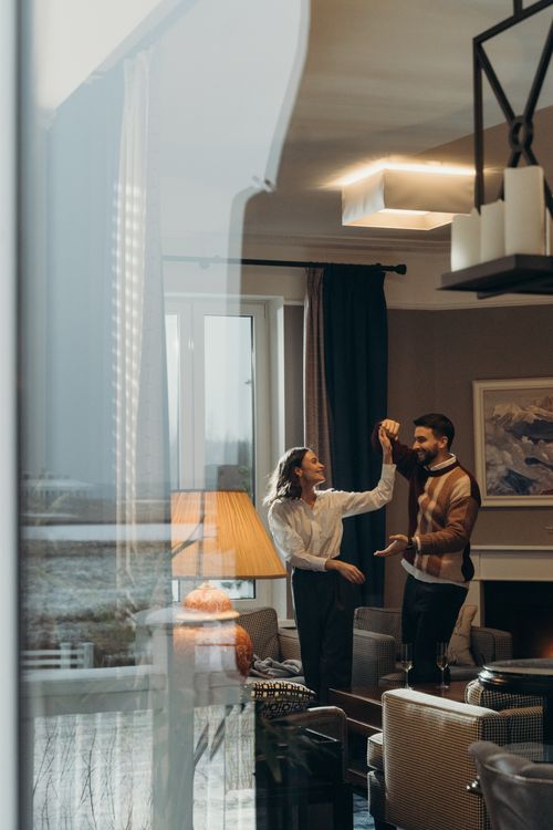Happy couple dancing together in a cozy, candlelit living room