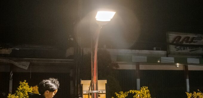 Man sitting alone at night checking his phone for a reply while online dating