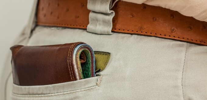 A wallet with cash inside a pocket, symbolizing the financial tribute at the center of financial domination