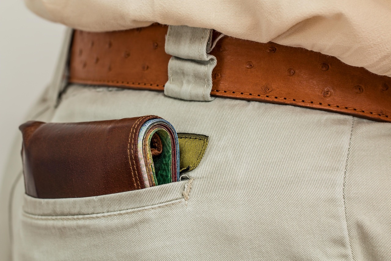 A wallet with cash inside a pocket, symbolizing the financial tribute at the center of financial domination