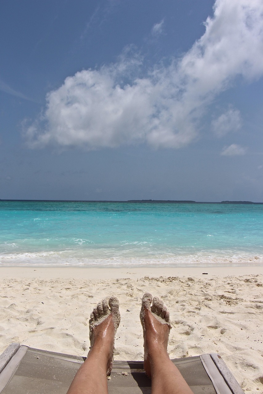 Bare feet in the sand at the beach, illustrating the everyday, non-taboo side of one of the most common fetishes