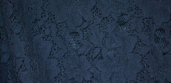Close-up of delicate lace fabric texture, representing the materials at the center of fetish fashion psychology
