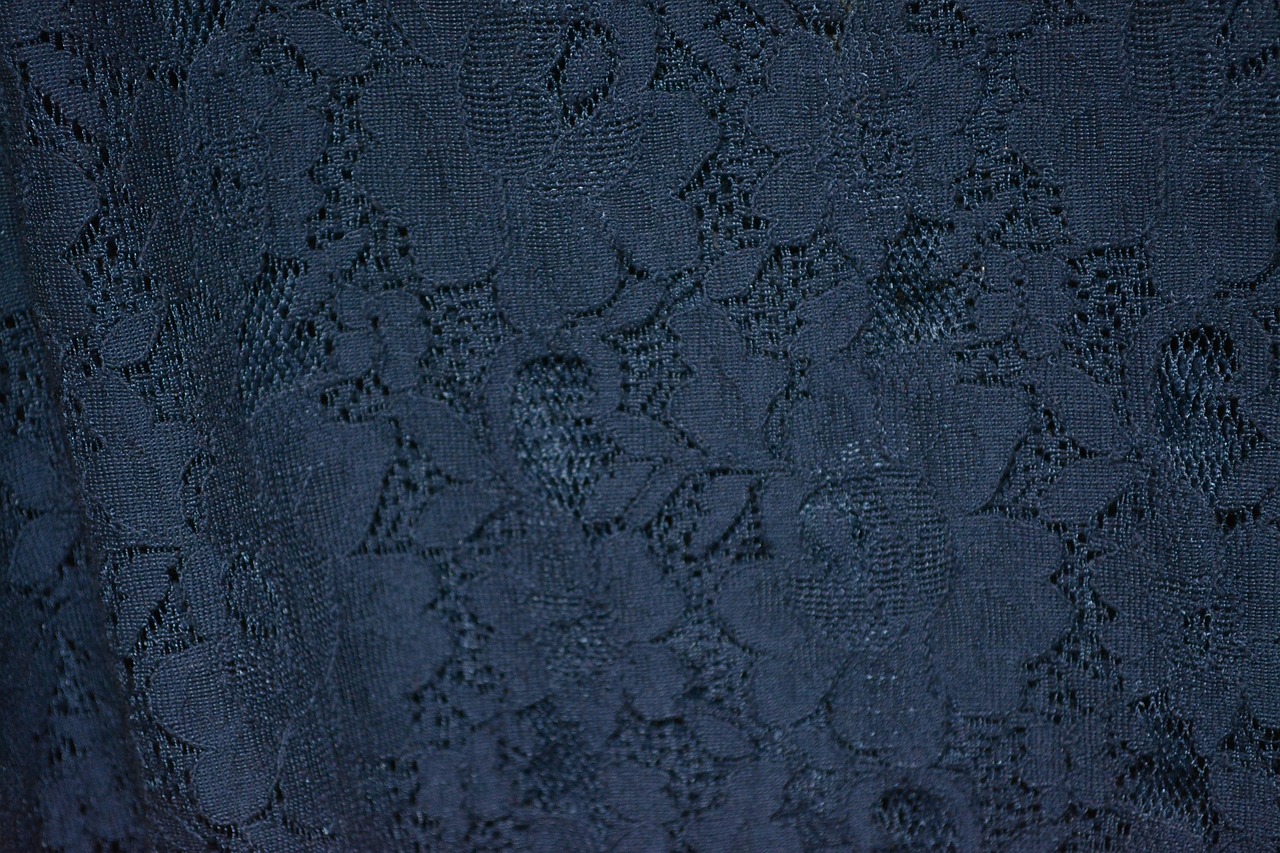 Close-up of delicate lace fabric texture, representing the materials at the center of fetish fashion psychology