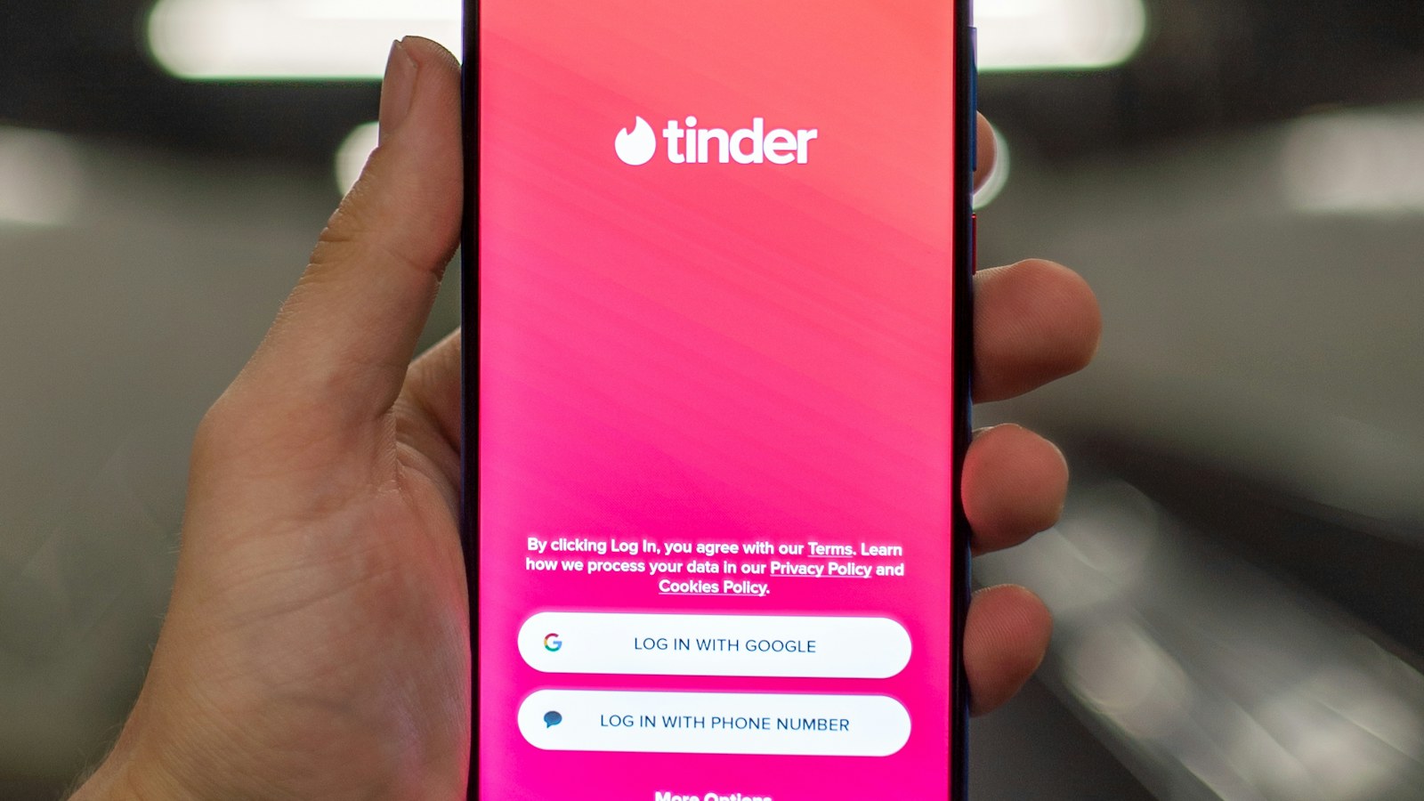 A person holding a smartphone showing a dating app, the starting point for vetting a match before the first date